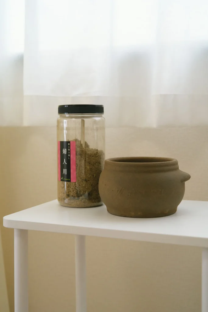 asuca黄土漢方よもぎ蒸しのツボと薬草が机に置いてある風景